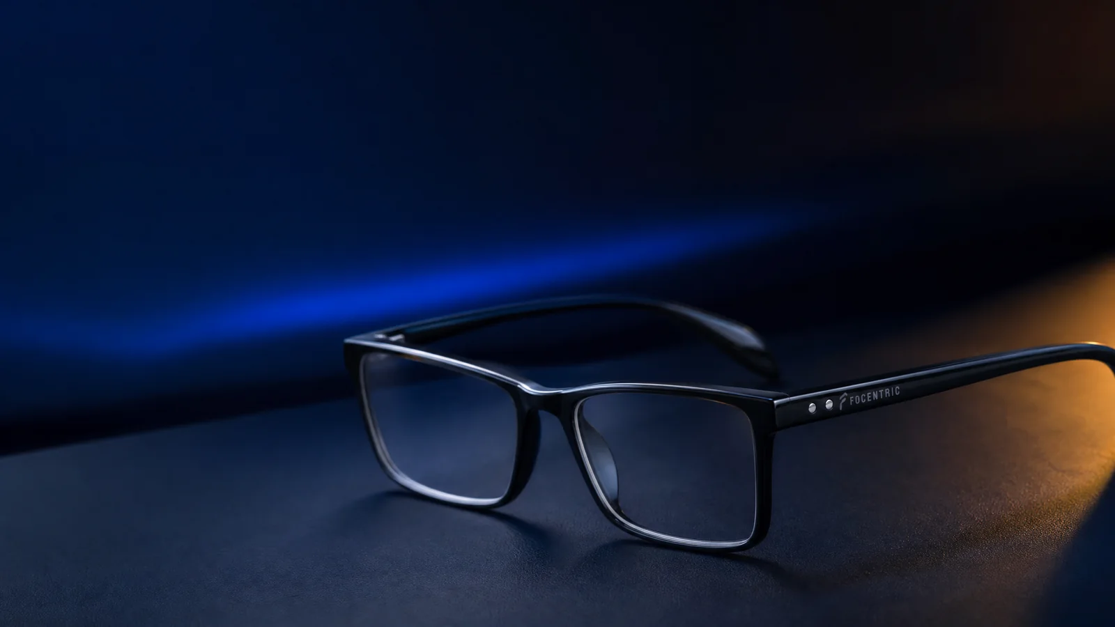 Focentric Brille in einer dunklen Blau-Gold-Produktinszenierung